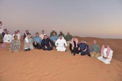 وزير الداخلية جالساً على الرمال مع موظفي “أرامكو” بالشرقية